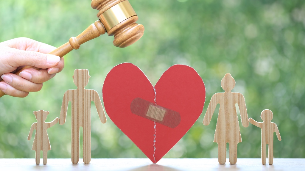 Divorce lawyer Or Attorney, Broken red heart with husband and wife splitting children on natural green background,Joint child custody and alimony concept.
