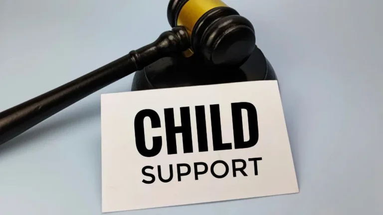 Judge's gavel resting on a surface next to a white card with "CHILD SUPPORT" in bold black letters.